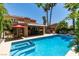 Inviting backyard pool with spa, complemented by a covered patio and lush tropical foliage for privacy at 5133 Southern Hills Ln, Las Vegas, NV 89113