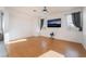 Bright living room with wood floors, neutral walls, and large windows with drapes at 5907 Soft Mist Ct, Las Vegas, NV 89110