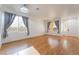 Bright living room with wood floors, neutral walls, and large windows with drapes at 5907 Soft Mist Ct, Las Vegas, NV 89110