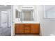 Bathroom with oak vanity, single sink, large mirror, and good natural light at 5938 Village Loft St, North Las Vegas, NV 89081