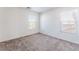 Bright bedroom features neutral carpet, white walls, and multiple windows offering natural light at 5938 Village Loft St, North Las Vegas, NV 89081