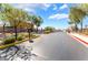 View of community entry gate with beautifully landscaped island and mature shade trees at 5938 Village Loft St, North Las Vegas, NV 89081