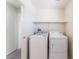 Bright laundry room features washer, dryer, overhead shelf and doorway at 5938 Village Loft St, North Las Vegas, NV 89081