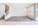 Open-concept living area with neutral paint, carpet and tile flooring, and natural light at 5938 Village Loft St, North Las Vegas, NV 89081