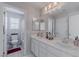 Bright bathroom with a double vanity and mirror, accented by natural light and a view of the bath at 6429 Joshuaville Dr, Las Vegas, NV 89122
