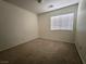 A bedroom with neutral walls, carpeted floors, and a window at 6608 Buried Treasure Ct, Las Vegas, NV 89139