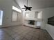 Bright living room with vaulted ceiling, tiled floors, fireplace, and neutral decor at 6608 Buried Treasure Ct, Las Vegas, NV 89139