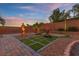 Landscaped backyard featuring stone pavers, garden beds, a decorative statue, and a fountain at 6958 Lazy Sunset Ct, Las Vegas, NV 89156