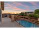 Balcony overlooking a landscaped backyard, pool, and mountain views creating a serene outdoor living space at 6958 Lazy Sunset Ct, Las Vegas, NV 89156