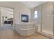 Bathroom showcasing tub with fireplace, tile flooring, and glass-enclosed shower at 6958 Lazy Sunset Ct, Las Vegas, NV 89156