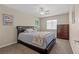 Comfortable bedroom with a ceiling fan, cozy bed, dresser, and a window for natural light at 6958 Lazy Sunset Ct, Las Vegas, NV 89156