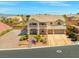 Two-story home boasts a balcony, three-car garage, desert landscaping, and brick-paver walkway at 6958 Lazy Sunset Ct, Las Vegas, NV 89156