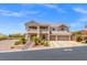 Elegant two-story home with a balcony, desert landscaping, and three-car garage at 6958 Lazy Sunset Ct, Las Vegas, NV 89156