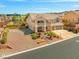 Attractive two-story house features a front balcony, desert landscaping, and a three-car garage at 6958 Lazy Sunset Ct, Las Vegas, NV 89156