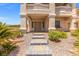 Stately home entrance features an elegant entryway, manicured landscaping, and stone paver steps at 6958 Lazy Sunset Ct, Las Vegas, NV 89156