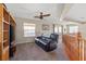 Comfortable living room in the loft with a ceiling fan, a plush couch, and ample natural light at 6958 Lazy Sunset Ct, Las Vegas, NV 89156