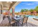 Covered patio featuring an outdoor dining set, pool, and landscaped backyard at 6958 Lazy Sunset Ct, Las Vegas, NV 89156