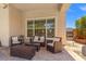 Covered patio area with cozy seating and a large window view at 6958 Lazy Sunset Ct, Las Vegas, NV 89156