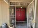 Up close image of red double doors with a security gate at the entry way with potted plants at 7104 Carrondale Way, Las Vegas, NV 89128