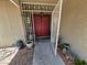 Open security gate reveals red double doors and potted plants on the home's walkway at 7104 Carrondale Way, Las Vegas, NV 89128