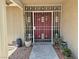 Home's decorative security gate protecting red double doors with potted plants at 7104 Carrondale Way, Las Vegas, NV 89128