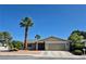 Welcoming home with a two-car garage, palm trees, desert landscaping, and a security gate at 7104 Carrondale Way, Las Vegas, NV 89128