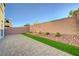 Backyard with a paver patio, decorative rock and a strip of synthetic grass along the wall at 7775 Tyrell Peaks St, Las Vegas, NV 89139