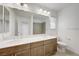 Bathroom with double vanity, large mirror, decorative vanity lights, and shower at 7775 Tyrell Peaks St, Las Vegas, NV 89139