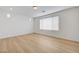 A spacious bedroom with light wood floors, white walls, and a large window for natural light at 7775 Tyrell Peaks St, Las Vegas, NV 89139