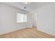 Bright bedroom with window and access to the walk-in closet with white painted door and wood-look laminate flooring at 7775 Tyrell Peaks St, Las Vegas, NV 89139