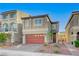 Charming two-story home features a red garage door and manicured landscaping in a well-maintained neighborhood at 7775 Tyrell Peaks St, Las Vegas, NV 89139