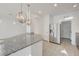 Bright kitchen features a large granite island, stainless steel refrigerator, and neutral tile flooring at 7775 Tyrell Peaks St, Las Vegas, NV 89139