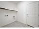 Clean and simple laundry room with white walls, tile floors, and a utility shelf at 7775 Tyrell Peaks St, Las Vegas, NV 89139