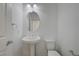 Bright powder room featuring a pedestal sink, oval mirror, and clean, white fixtures at 7775 Tyrell Peaks St, Las Vegas, NV 89139