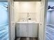 Laundry closet with white washer and dryer on wood-style flooring in between two bedrooms at 8125 Rio De Janeiro Dr, Las Vegas, NV 89128