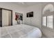 Bedroom features a large bed, arched window, TV and closet at 825 Royal Moon Ave, Las Vegas, NV 89123
