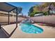 Backyard pool featuring rock waterfall, lush landscaping, and shaded pergola area at 825 Royal Moon Ave, Las Vegas, NV 89123