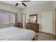 Well-lit bedroom with hardwood floors, a large window, and a wardrobe with mirror at 8656 Rowland Bluff Ave, Las Vegas, NV 89178