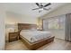 This bedroom features a vaulted ceiling, ceiling fan, a large window and hardwood floors at 8656 Rowland Bluff Ave, Las Vegas, NV 89178