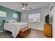 Cozy bedroom with light-colored walls and wood-look flooring; features a ceiling fan and a large window at 8656 Rowland Bluff Ave, Las Vegas, NV 89178