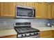 Close-up of the kitchen showcasing the stainless steel oven, microwave, and countertops at 8656 Rowland Bluff Ave, Las Vegas, NV 89178