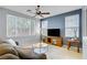 Bright living room with large windows, a ceiling fan, and a stylish TV stand at 8656 Rowland Bluff Ave, Las Vegas, NV 89178