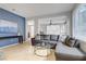 Cozy living room with tile floors, a comfortable gray sofa, and ample natural light at 8656 Rowland Bluff Ave, Las Vegas, NV 89178