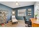 Welcoming office space with blue walls, a large window, and shelving units for storage at 8656 Rowland Bluff Ave, Las Vegas, NV 89178