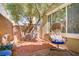 Cozy patio with brick pavers, a stylish egg chair, and a peaceful tree at 8656 Rowland Bluff Ave, Las Vegas, NV 89178