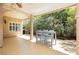 Comfortable covered patio featuring outdoor dining and living area with lush backyard landscaping and relaxing ambiance at 8875 Tidal Bay Dr, Las Vegas, NV 89117