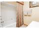 Bright bathroom featuring a white tub with shower, white tile surround, and neutral colored shower curtain and towels at 8875 Tidal Bay Dr, Las Vegas, NV 89117