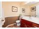 Powder room with white vanity, wood-trimmed mirror and wainscotting at 8875 Tidal Bay Dr, Las Vegas, NV 89117