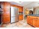 Kitchen showcasing stainless steel refrigerator, oak cabinets, green countertops and tile backsplash at 8875 Tidal Bay Dr, Las Vegas, NV 89117