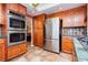 This kitchen features built in stainless ovens, stainless refrigerator, and oak cabinets at 8875 Tidal Bay Dr, Las Vegas, NV 89117